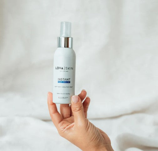 Flacone bianco da 100 ml con erogatore trasparente e etichetta Lovaskin idratante tenuto da mano femminile su sfondo chiaro. - LOVASKIN -  KIT Pedicure Professionale - 100 ml + raspa e pochette