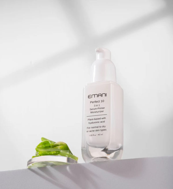 Flacone trasparente con dispenser bianco di siero primer Emani Perfect 10, 35 ml, su superficie bianca con foglie verdi. - Perfect 10 primer & serum NEW - 35 ml